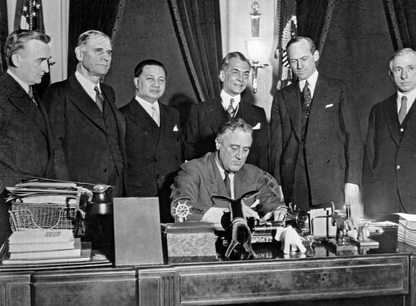 Franklin Roosevelt signing New Deal legislation, surrounded by supporters, 1930s