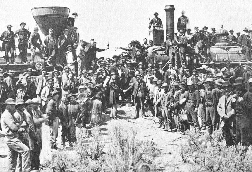 Chinese laborers and a Central Pacific locomotive at the completion of the transcontinental railroad in 1869