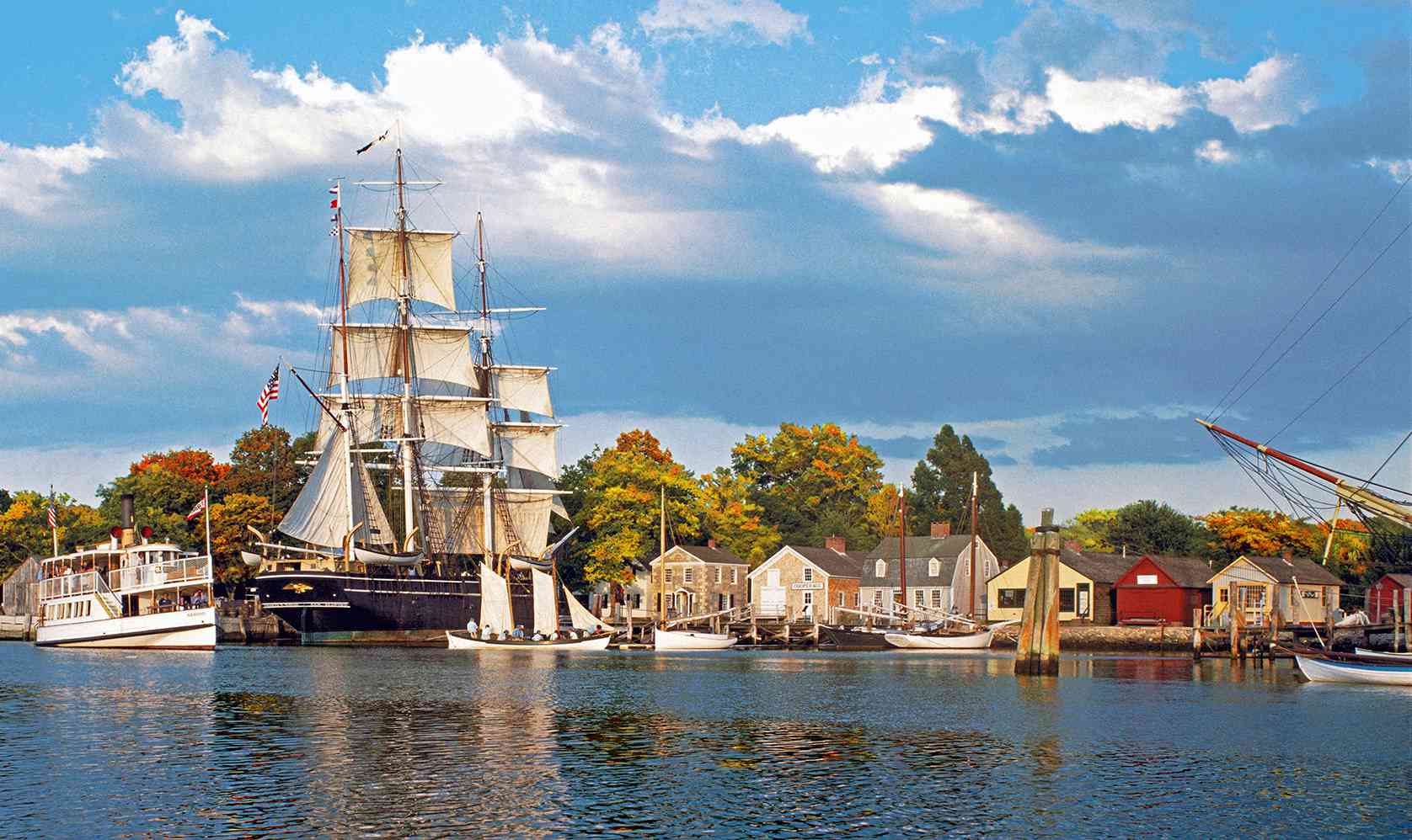 Tall ship masts and historic waterfront buildings at Mystic Seaport Museum, Connecticut
