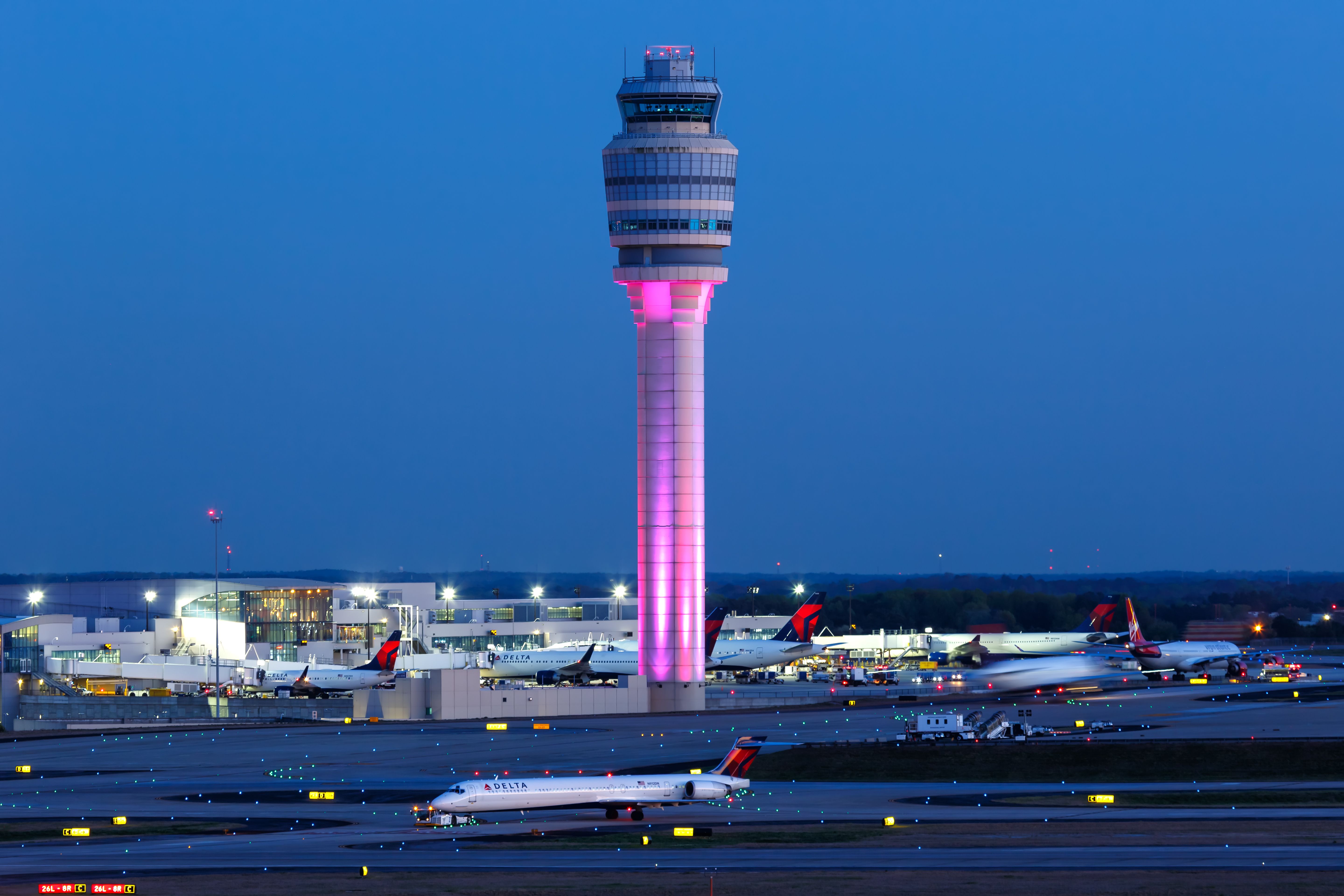Aerial view of Hartsfield-Jackson Atlanta International Airport with dozens of aircraft at gates and runways stretching across the Georgia landscape